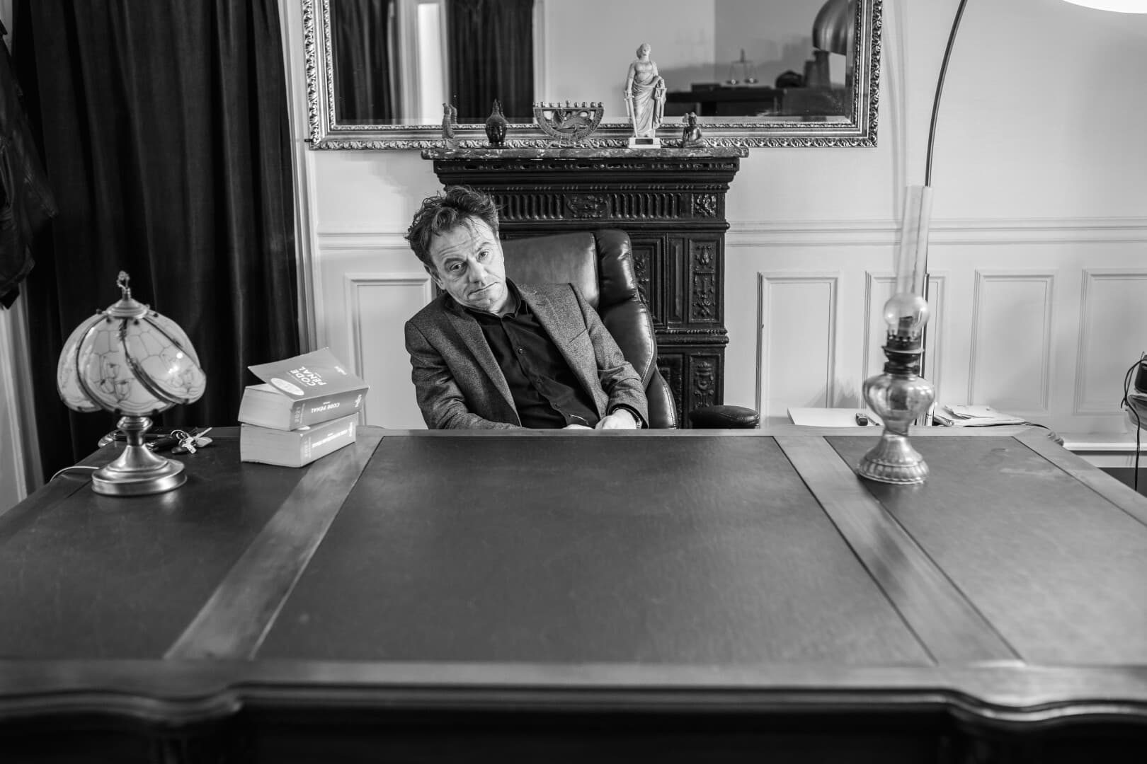 Maître Romuald Sayagh dans son bureau, devant la cheminée du cabinet